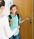 Boy and mother staying near flat entrance and talking