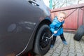 Boy mounted tires on a car. Royalty Free Stock Photo