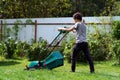 Boy mowing the lawn with lawnmower Royalty Free Stock Photo