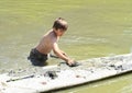 Boy muddying surfboard in water Royalty Free Stock Photo