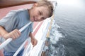 Boy near handrails on deck of ship