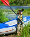Boy near a kayak on the river Royalty Free Stock Photo