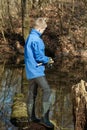 Boy near log fishing at shallow pond Royalty Free Stock Photo