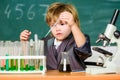 Boy near microscope and test tubes in school classroom. Science concept. Gifted child and wunderkind. Kid study