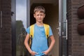 Boy near residential apartment house ready to go to school