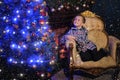 The boy next to a glowing blue Christmas tree and fireplace Royalty Free Stock Photo