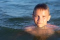 A boy of nine is swimming in the sea at sunset Royalty Free Stock Photo