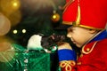 A boy in a nutcracker costume plays with the mouse symbol of the year.