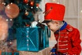 A boy in a nutcracker costume plays with the mouse symbol of the year.