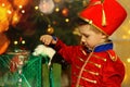 A boy in a nutcracker costume plays with the mouse symbol of the year.