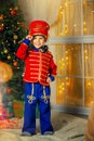 A boy in a nutcracker costume plays with the mouse symbol of the year.