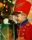 A boy in a nutcracker costume plays with the mouse symbol of the year.