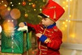 A boy in a nutcracker costume plays with the mouse symbol of the year.