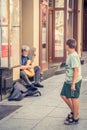 Boy observing man playing guitar in Torun Old Town