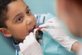 Boy opening mouth while dentist putting mouth guard