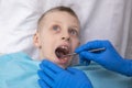 boy opens her mouth wide and pulls out long tongue. child shows his teeth soft palate and mouth to dentist. mouth is Royalty Free Stock Photo