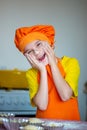 boy in orange apron cooking in the kitchen Royalty Free Stock Photo