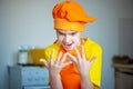 boy in orange apron cooking in the kitchen Royalty Free Stock Photo