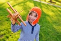 Boy in orange helmet pilot playing in toy wooden plane against grass background Royalty Free Stock Photo