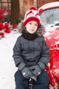 Boy outdoor near Chrstmas tree. Sitting