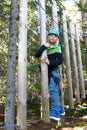 Boy overcoming hanging logs obstacle Royalty Free Stock Photo