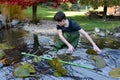 Boy helps cleaning the garden pond Royalty Free Stock Photo
