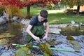 Boy helps cleaning the garden pond Royalty Free Stock Photo