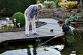 Boy and grandmother cleaning garden pond Royalty Free Stock Photo