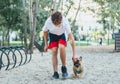 The boy owner of french bulldog trains the dog in the park. Dog training with teenager and bulldog outdoor. Still life, love Royalty Free Stock Photo