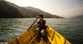 Boy paddling yellow canoe