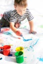 Boy painting, focus on cans