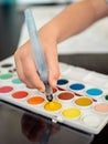 Boy draws with watercolors and waterbrush Royalty Free Stock Photo