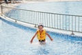 Boy in panama and child life vest bathes in the pool