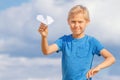 Boy with paper plane against blue sky Royalty Free Stock Photo