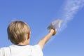 Boy with paper plane against blue sky. Low angle view Royalty Free Stock Photo