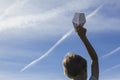 Boy with paper plane in his hand against blue sky. Low angle view Royalty Free Stock Photo