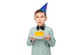 boy in party hat blowing candle on birthday cake Royalty Free Stock Photo