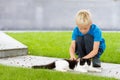 Boy patting a cat outside