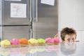 Boy Peaking Over Counter At Row Of Cupcakes Royalty Free Stock Photo