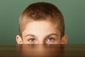 Boy peeping out table surface