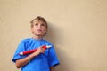 Boy with pencil stands and looks up.