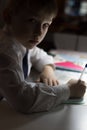 Boy with pencil writing english words by hand on traditional white notepad paper. Royalty Free Stock Photo