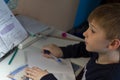 Boy with pencil writing english words by hand on traditional white notepad paper. Royalty Free Stock Photo