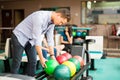 Boy Picking Up Bowling Ball From Rack In Club Royalty Free Stock Photo