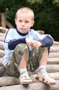 Boy on pile of logs