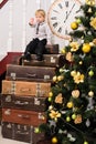 Boy on pile of suitcases at christmas tree Royalty Free Stock Photo