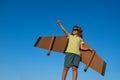 Boy pilot against a blue sky. Cute dreamer boy playing with a cardboard airplane. Childhood. Fantasy, imagination. Royalty Free Stock Photo