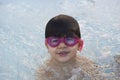 Boy with pink swimming goggles having fun in a hydromassage bath