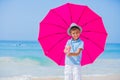 Boy with a pink umbrella on the sandy beach Royalty Free Stock Photo