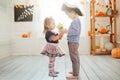 Boy in a pirate costume and a girl in a witch costume celebrates Halloween at home. A boy gives flowers to a girl. Royalty Free Stock Photo